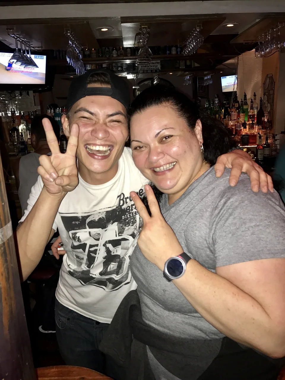andre and woman laughing behind bar